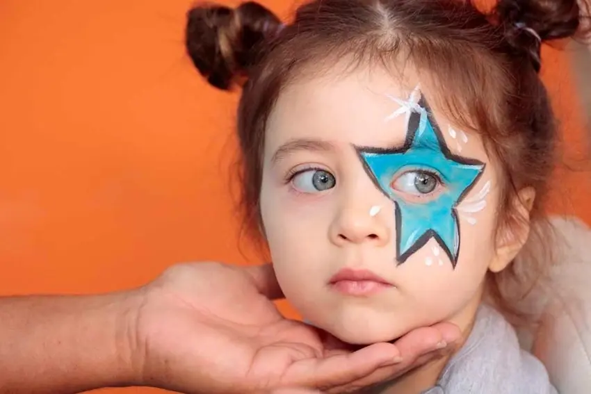 Girl with star face paint over her one eye