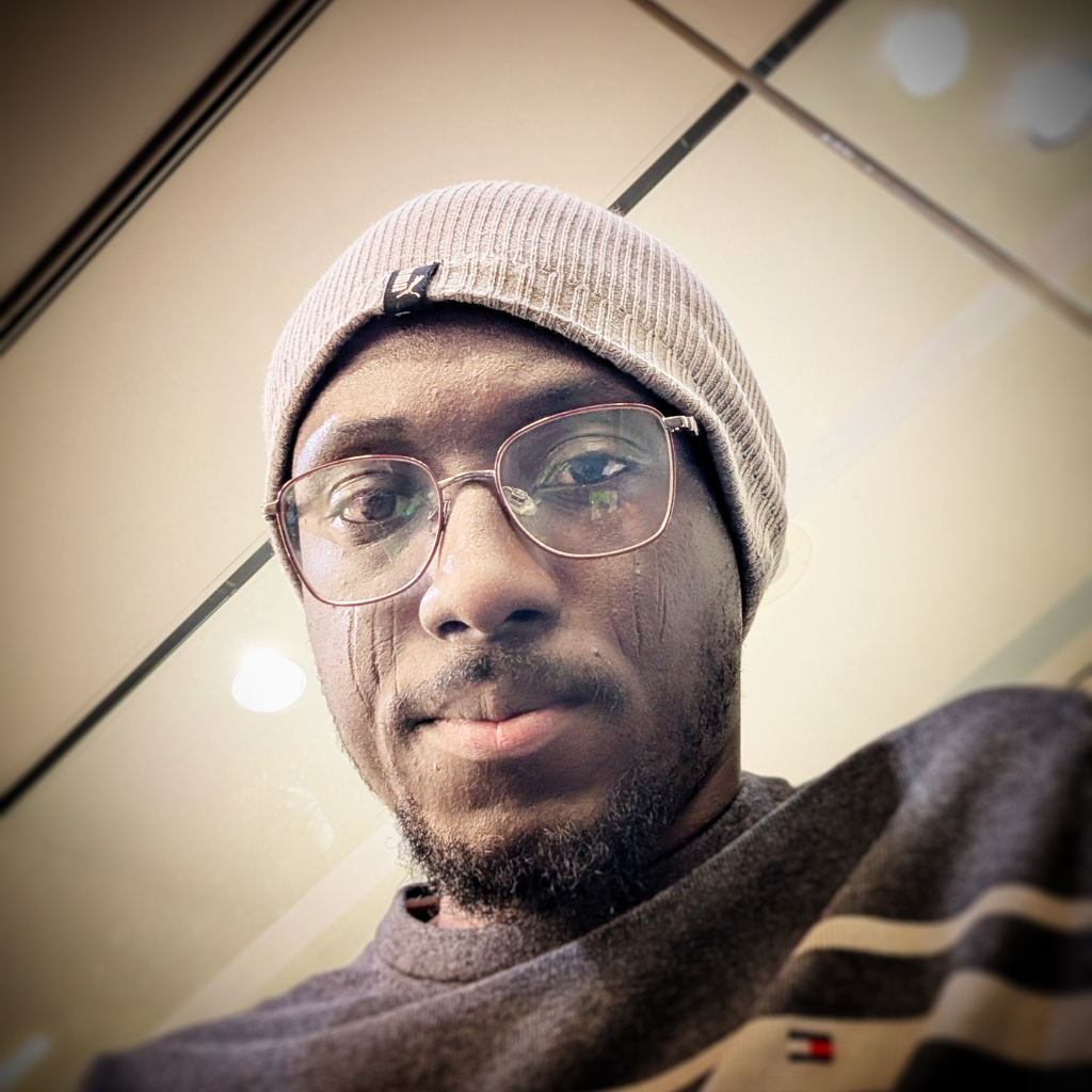 Abdulmalik Nuhu, Chamber President, wearing glasses and a beanie, smiling at the camera